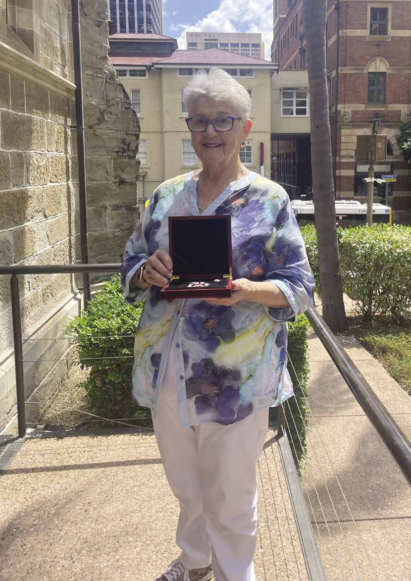 Trish holding her Quinn Medal outside the cathedral